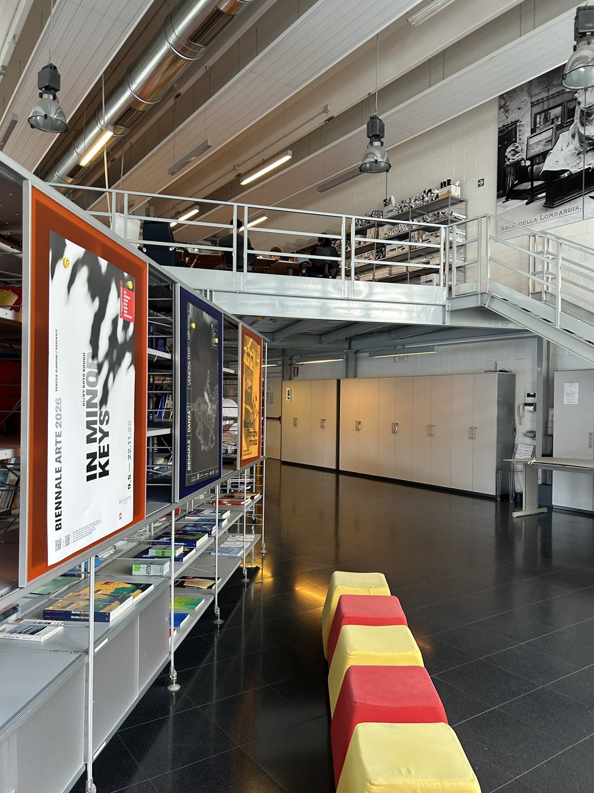 Exhibition posters and publications on display in an archive